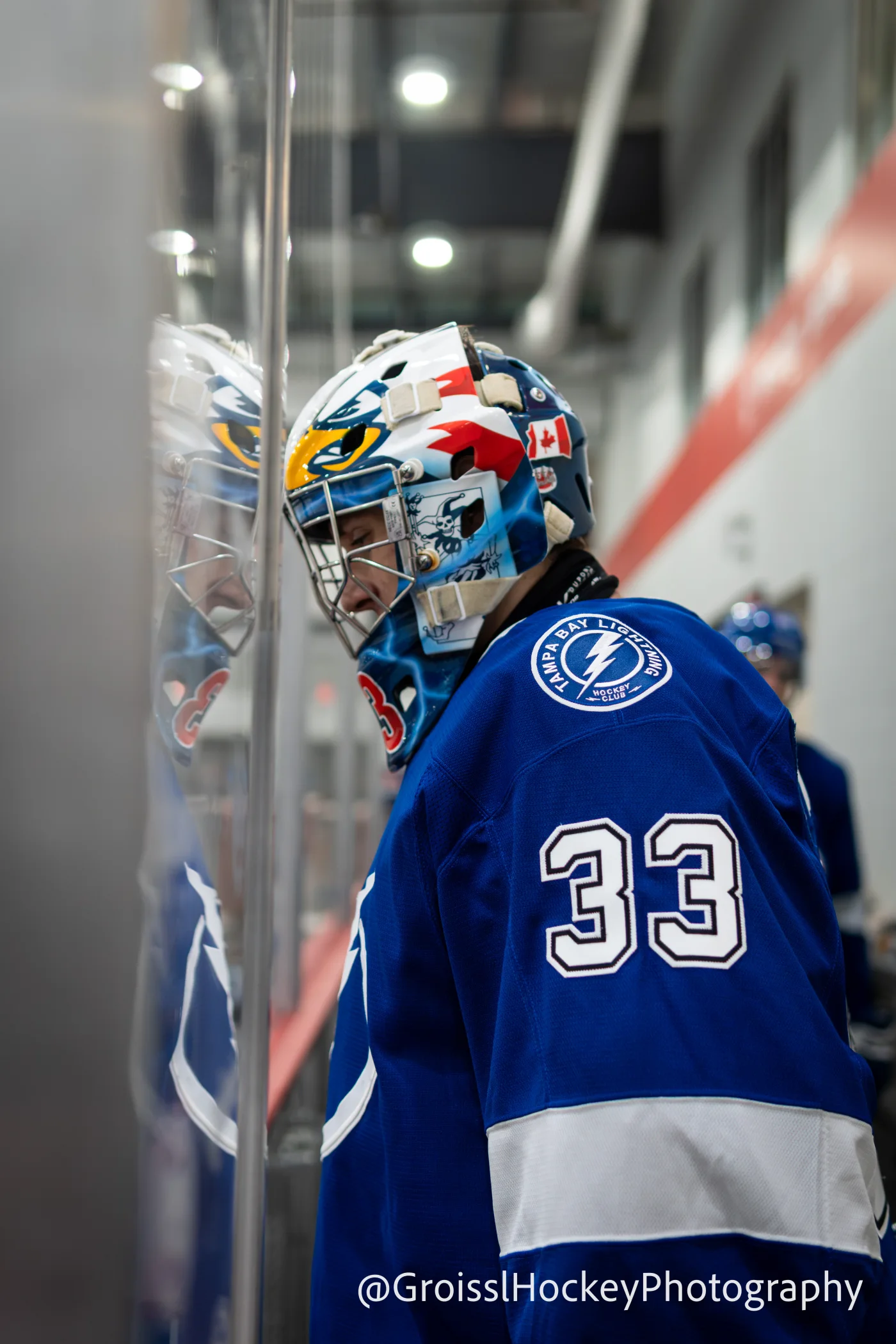 Tampa Bay Lightning goaltender wearing number 33 beside the rink glass