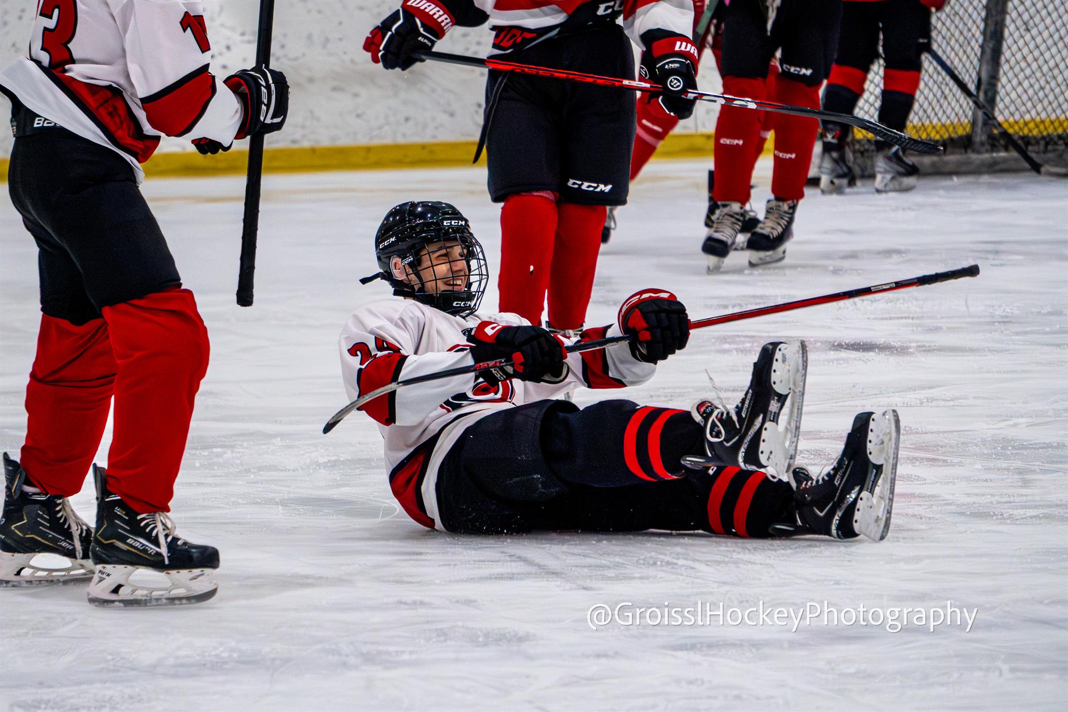Player on ice with teammates in the background