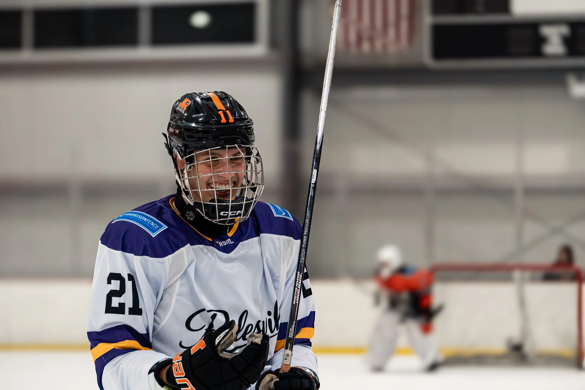 Team Rolesville player smiling with stick upright after the play